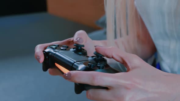 Relaxing Woman Playing Console Indoors. Young Casual Woman Chilling on Sofa and Playing Video Game