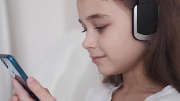 Cute Girl Enjoying Music with Headphones at Home