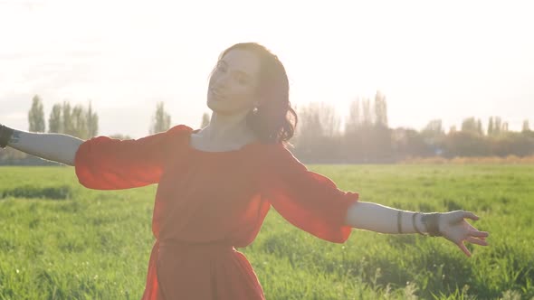 Beautiful Spanish Brunette Woman in Red Dress Dancing at Sunset in Wheat Field