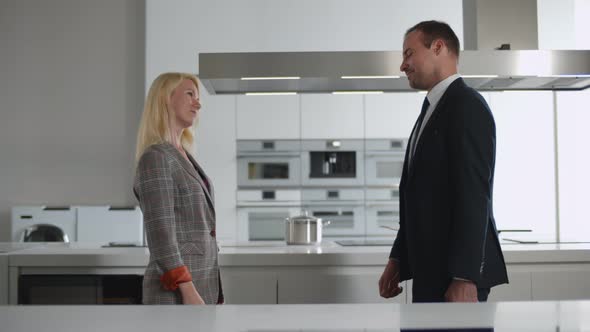 Side View of Customer and Consultant Shaking Hands in Modern Kitchen Furniture Showroom