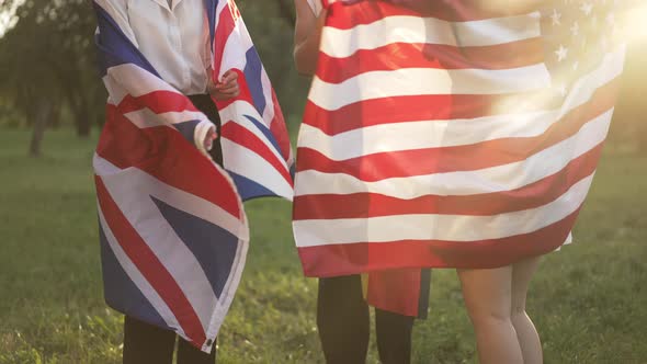 Unrecognizable Young People in National Flags Dancing in Sunshine in Slow Motion Outdoors