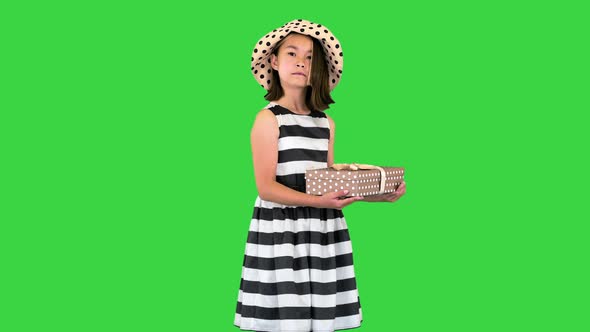 Little Asian Girl Offering a Gift in a Box To Camera on a Green Screen Chroma Key