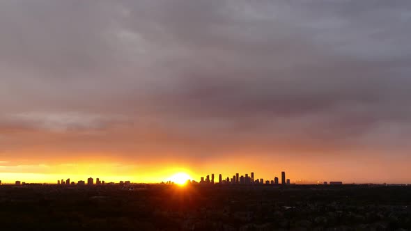 Time-lapse of sun rising behind Mississauga skyline as clouds roll in.