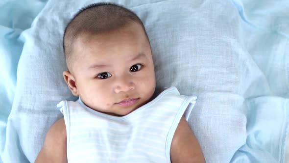 slow-motion of happy baby lying on a bed at home