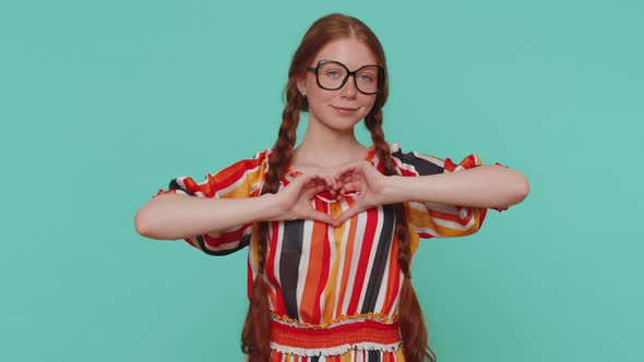 Smiling Ginger Girl Makes Heart Gesture Demonstrates Love Sign Expresses Good Feelings and Sympathy