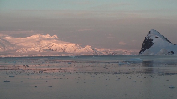 Sunset in Antarctica, with calm sea water.