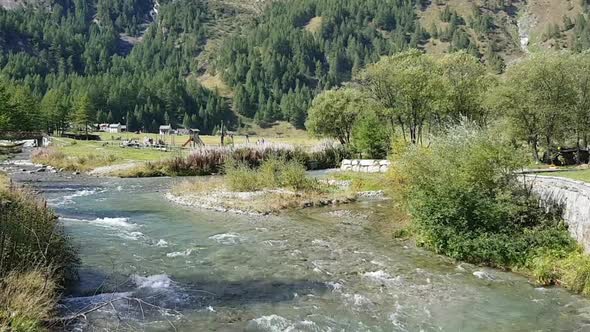 Children And Families Having Fun In A Park Between The Mountains And Close To A River