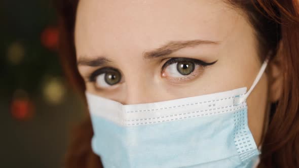 Very Close View Serious Young Woman in Surgical Mask Looks at you