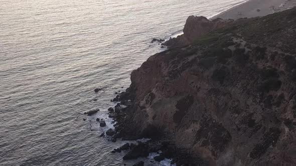 AERIAL: Flight Over Malibu, California View of Beach Shore Line Pacific Ocean at Sunset with