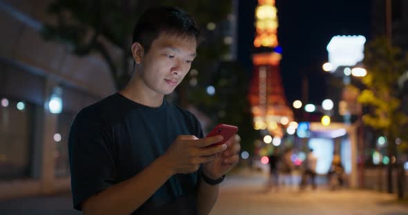 Man use of mobile phone in Tokyo city at night