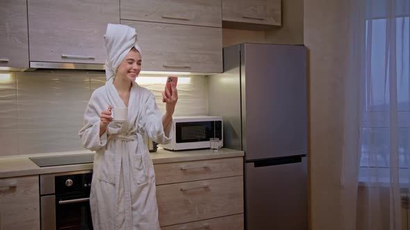 Girl in Bathrobe with Towel on Her Head Uses Phone for Work From Home Slow Motion