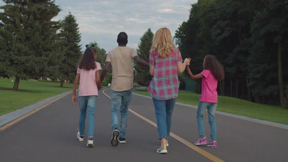 Happy Multiracial Family with Kids Bonding in Park