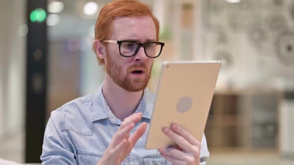 Upset Young Redhead Man Reacting to Loss on Tablet
