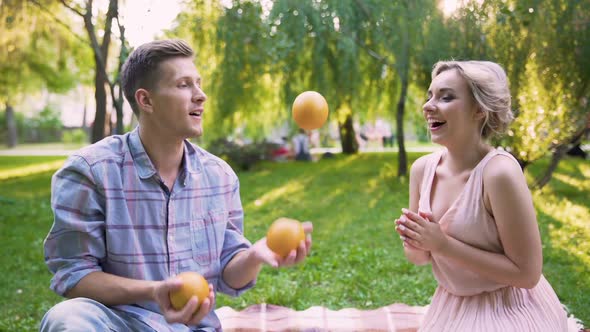 Boyfriend Surprising and Cheering Lady Making Tricks and Juggling with Oranges