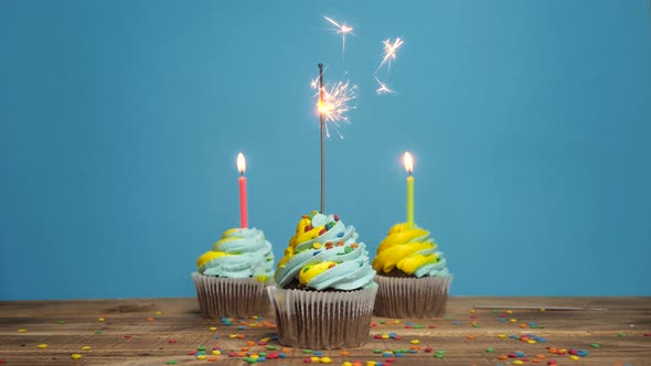 Birthday Cupcake with Candles and Decorations on a Blue Background