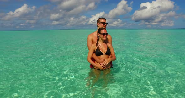 Young people in love dating on vacation enjoy luxury on beach on sunny white sandy 4K background