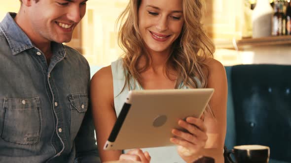 Smiling couple using digital tablet