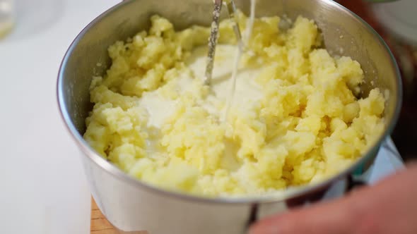 a Female Hand Mashes Boiled Potatoes with a Pusher and Adds Milk to It Mixes Making Mashed Potatoes