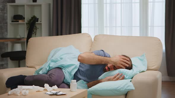 Ill Man Laying on Sofa alt