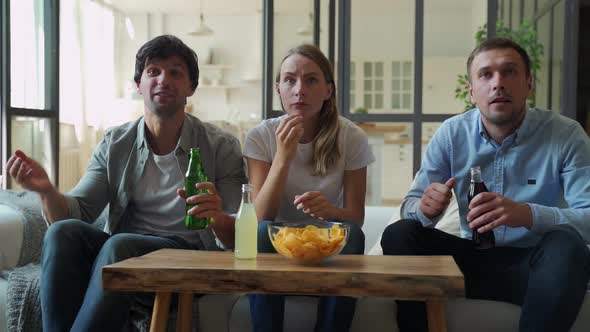 Funny Friends Celebrate the Victory of Their Favorite Team Sitting on the Couch