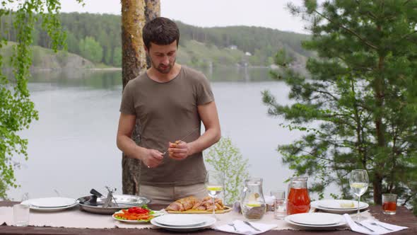 Man Putting Meat on Skewer Outdoors