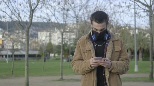 Masked Man Using Phone