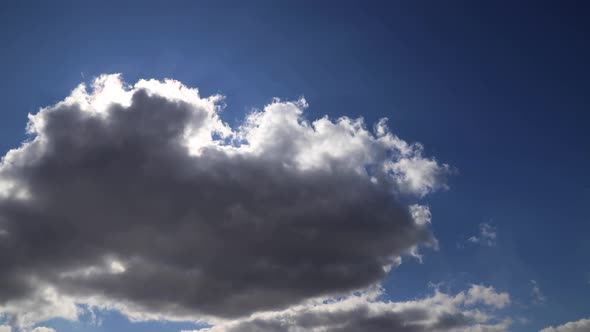 Time lapse: tense fluffy clouds cover the sun. Sun rays brake through clouds.