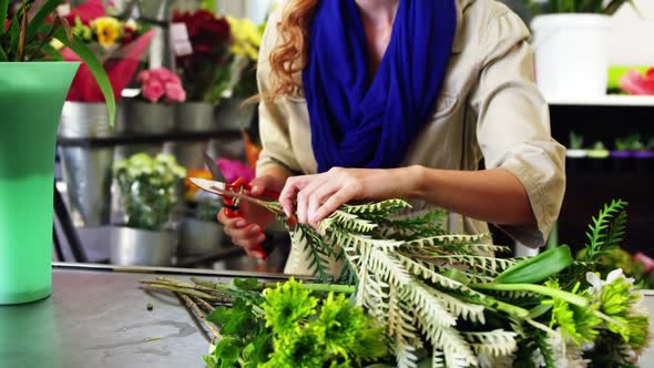 Female florist trimming plant