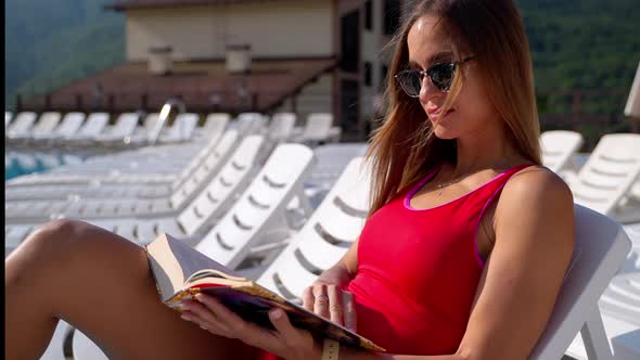 Hotel Guest Reading a Book at Poolside