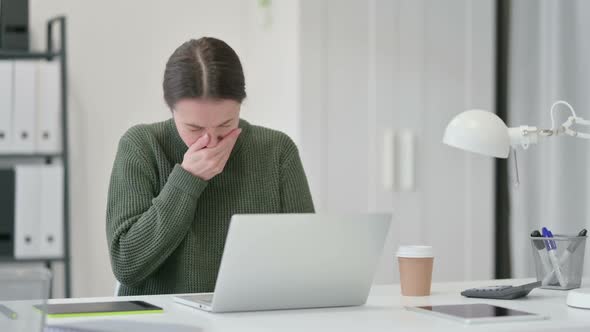 Young Woman Sneezing at Work