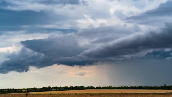 Storm Clouds Moving in Time Lapse Over the Barley Fields. Cloudy Landscape with Summer Rain