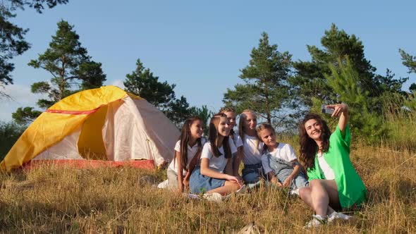 Group of Schoolchildren with a Teacher with Tents in Nature