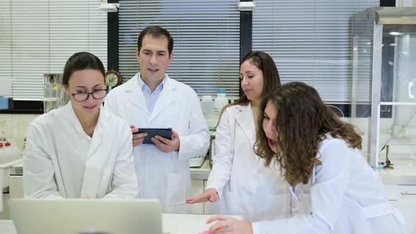 Group of scientists discussing research details in lab