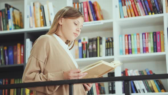 Girl Reading Book in Book Shop alt