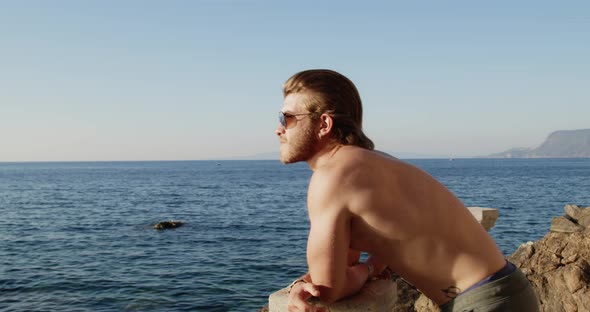 Young boy facing out with bare chested sunglasses