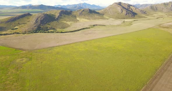 Lush Green Hills And Field Near Rural Town In Buenos Aires, Argentina. aerial tilt-up