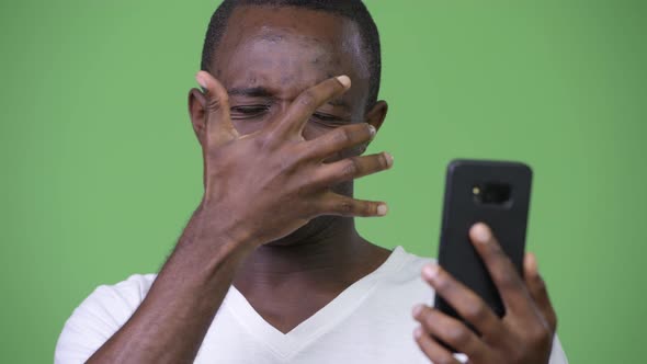 Young Sad African Man Using Phone and Getting Bad News