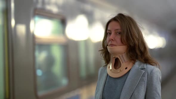 Woman with Osteochondrosis Is Standing in Metro Station, Wearing Neck Brace for Curing Ache in