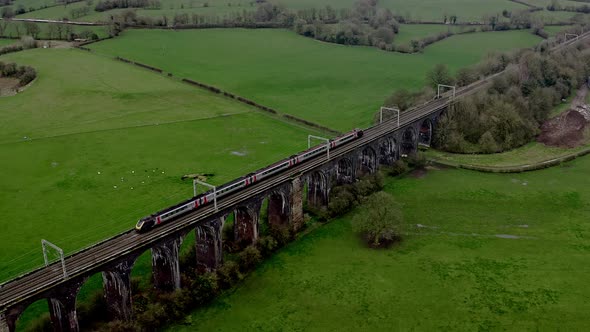 An aerial view of the a large Buxton railway bridge viaduct as trains pass in the Derbyshire Peak Di