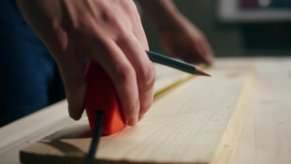 Woman Builder Using Roulette Wheel and Drawing Mark on Wooden Board Closeup