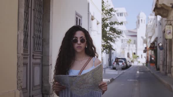 Woman on Summer Holidays Holding Map and Walking in City