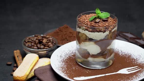 Classic Tiramisu Dessert in a Glass and Cup of Coffee on Dark Concrete Background