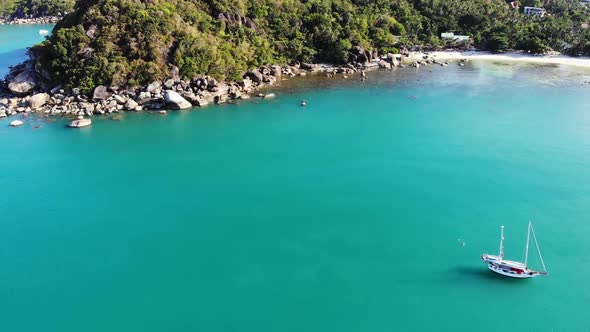 Boat Near Tropical Shore. Amazing Drone View of Modern Yacht Sailing on Calm Sea Water Near Coast