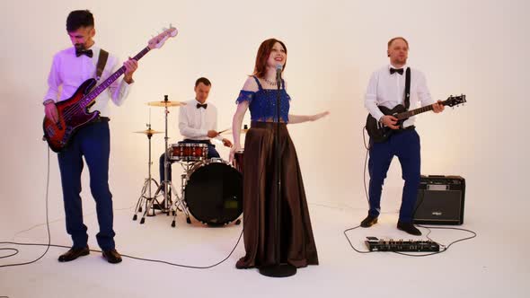 A Musical Band of Four Mature People Playing Song in the Studio