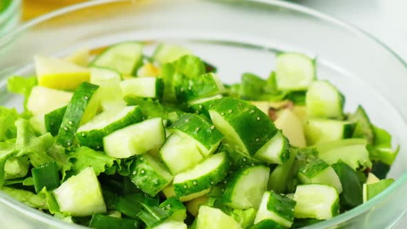 Woman Cooking Salad of Fresh Green Vegetables and Herbs