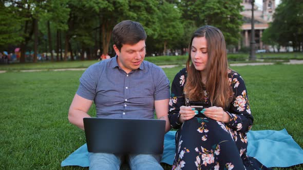 Young Handsome Married Couple Shopping Online Using Laptop and Credit Card