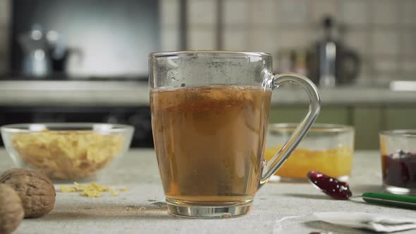 Whole grain biscuit falls into the cup of hot tea slow motion 100 fps