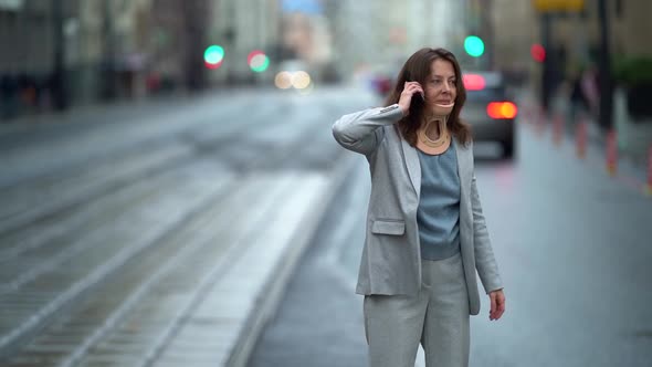 Townswoman with Cervical Collar Is Calling By Mobile and Waiting Bus or Tram on Road in City, Curing