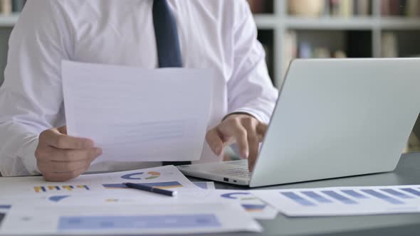 Close Up Shoot of Businessman Using Laptop and Documents