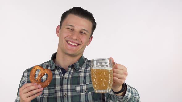 Handsome Cheerful Man Holding Out Delicious Beer in a Mug To the Camera